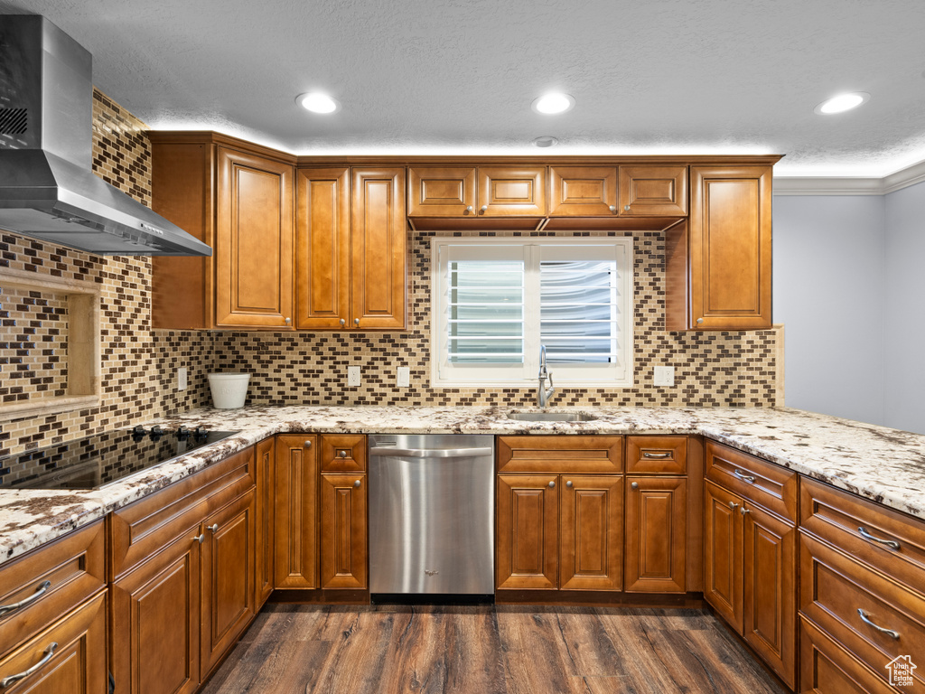 Kitchen with dishwasher, wall chimney range hood, black electric cooktop, a sink, and dark wood-style floors