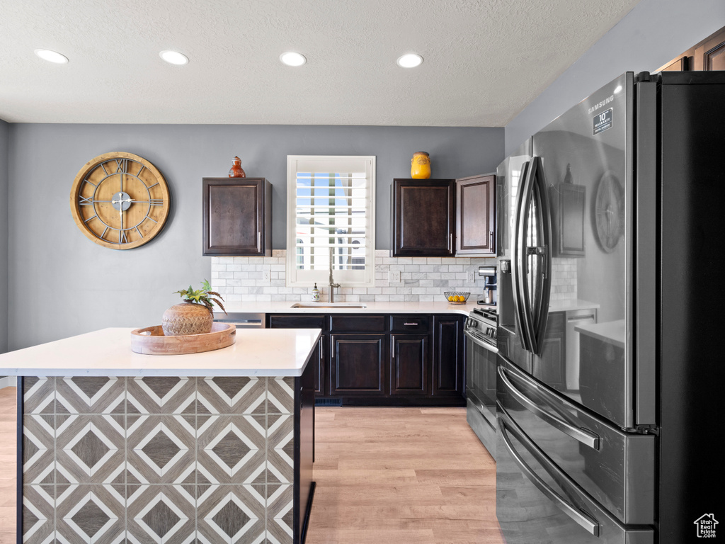 Kitchen featuring stainless steel appliances, a sink, light countertops, light wood-style flooring, and recessed lighting