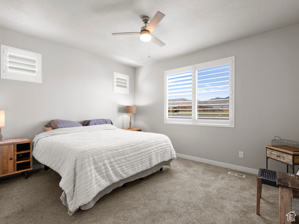 Carpeted bedroom with baseboards and ceiling fan