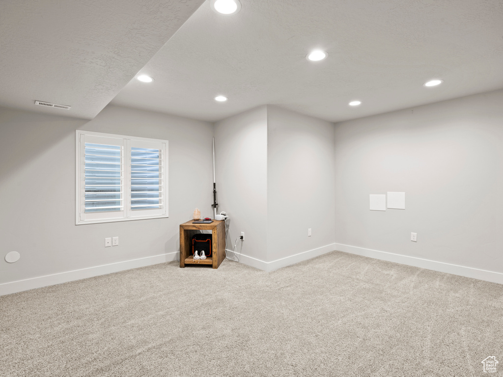 Below grade area with light colored carpet, recessed lighting, and baseboards