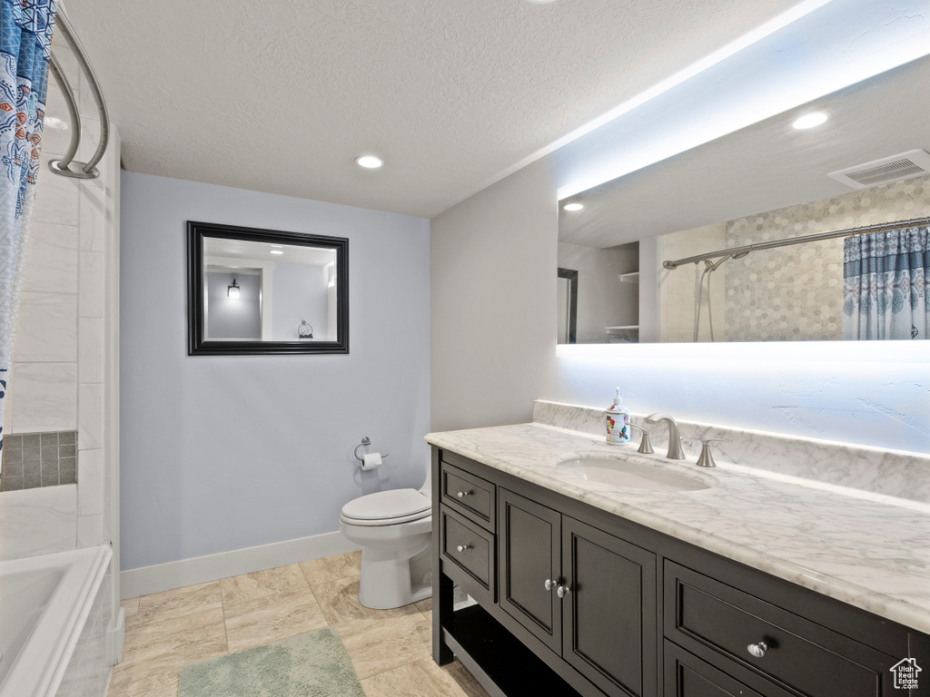 Full bathroom with vanity, baseboards, toilet, recessed lighting, and a textured ceiling