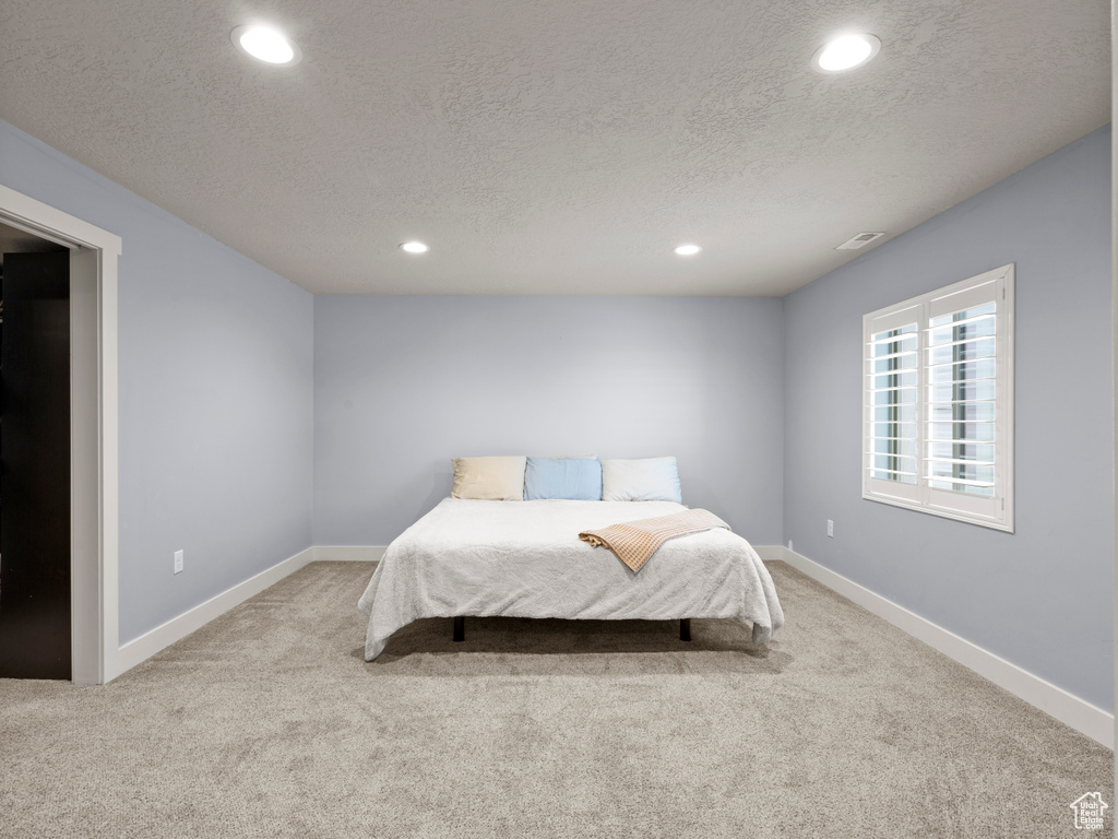 Carpeted bedroom with recessed lighting, a textured ceiling, and baseboards