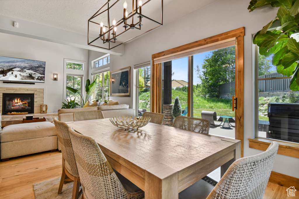 Dining area featuring light wood-style flooring, a fireplace, and a textured ceiling