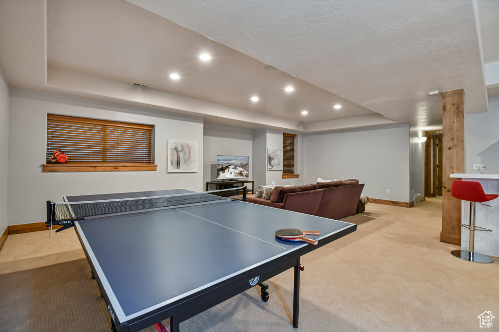 Game room featuring light carpet, baseboards, recessed lighting, and a raised ceiling