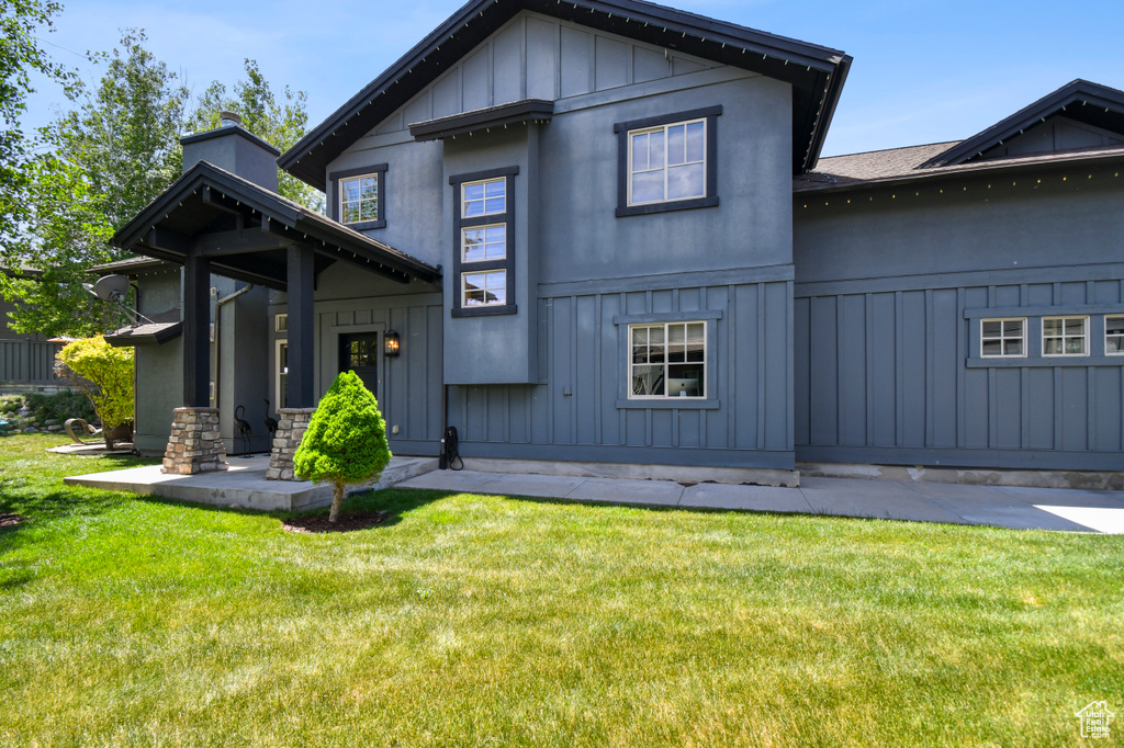 View of front of house with board and batten siding and a front lawn