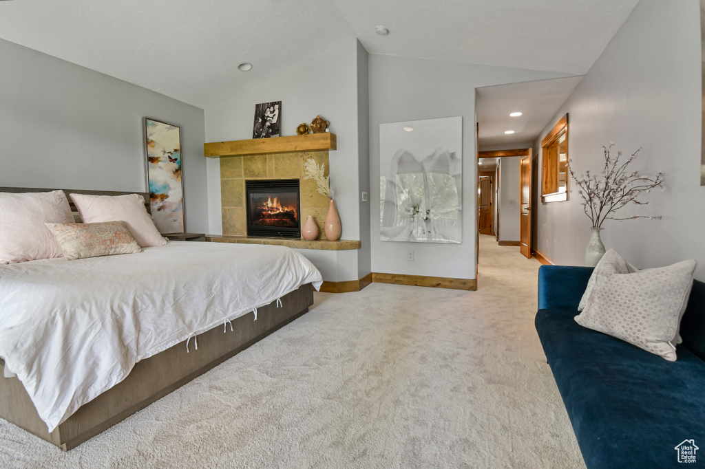 Bedroom with carpet flooring, lofted ceiling, a fireplace, baseboards, and recessed lighting
