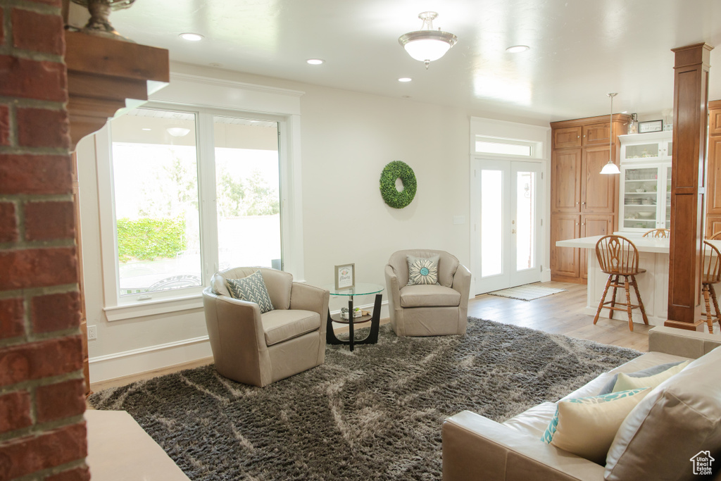 Living room with plenty of natural light, light wood-style floors, baseboards, and recessed lighting