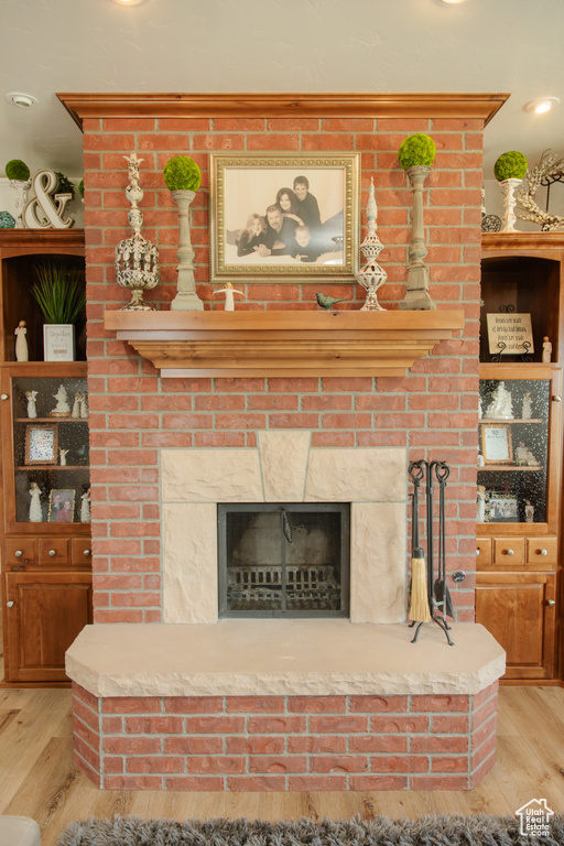 Detailed view of wood finished floors and a brick fireplace