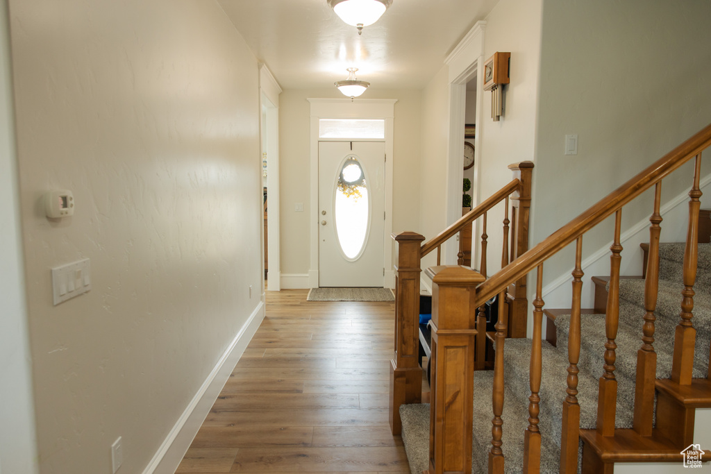 Foyer featuring hardwood / wood-style floors, stairs, and baseboards