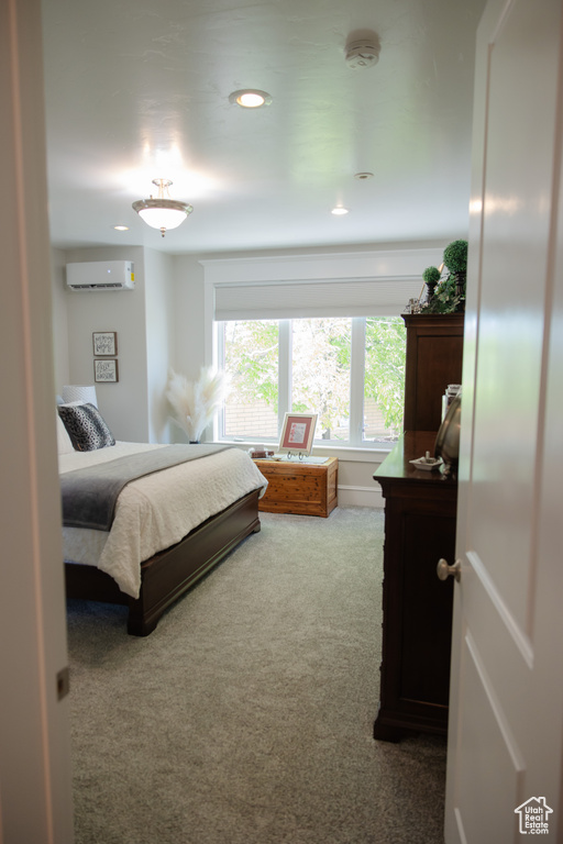 Bedroom featuring a wall mounted AC, carpet flooring, and recessed lighting