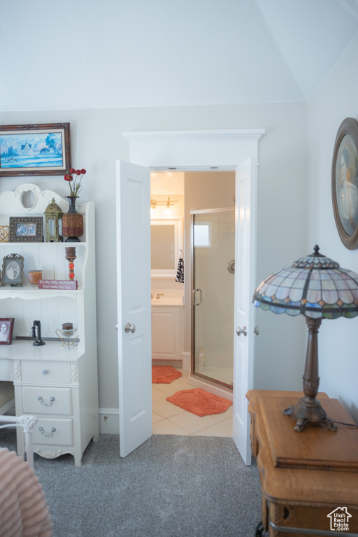 Bedroom featuring light colored carpet, light tile patterned flooring, an office area, and baseboards