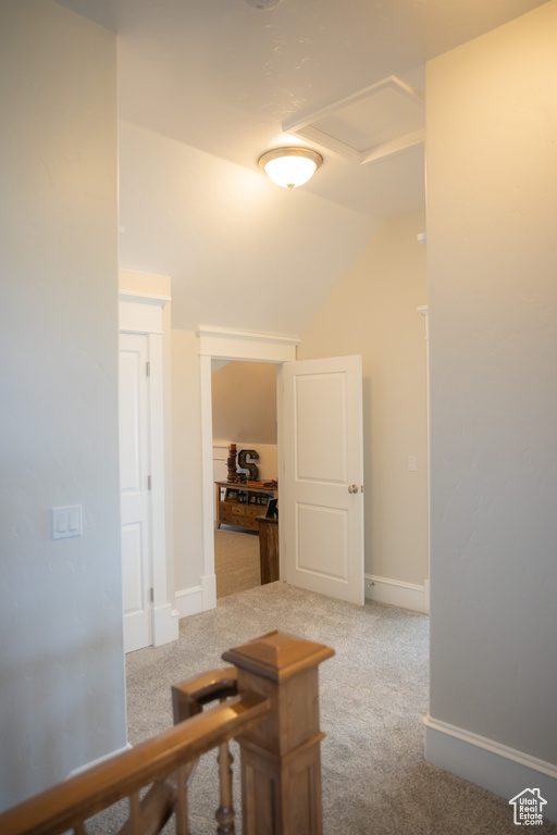 Hall with carpet floors, vaulted ceiling, and baseboards