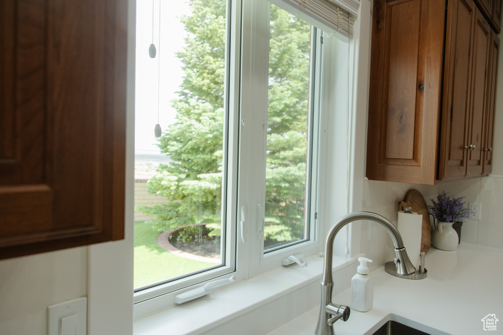 Kitchen view of light countertops, brown cabinets, and a sink