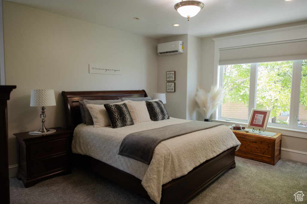 Carpeted bedroom featuring a wall unit AC, recessed lighting, and baseboards