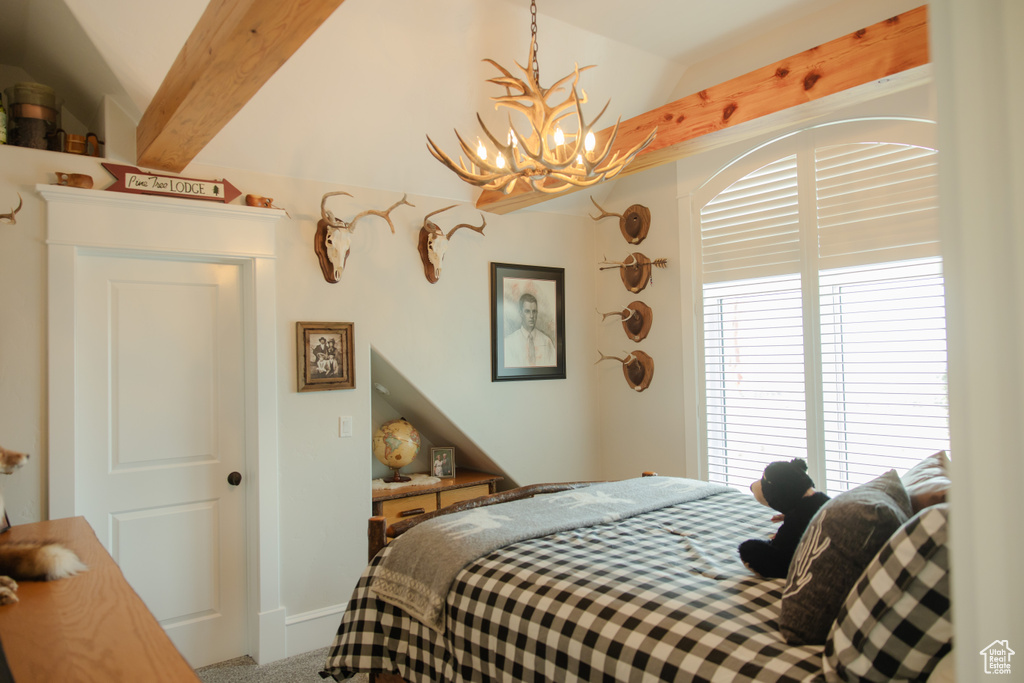 Carpeted bedroom with a chandelier and multiple windows