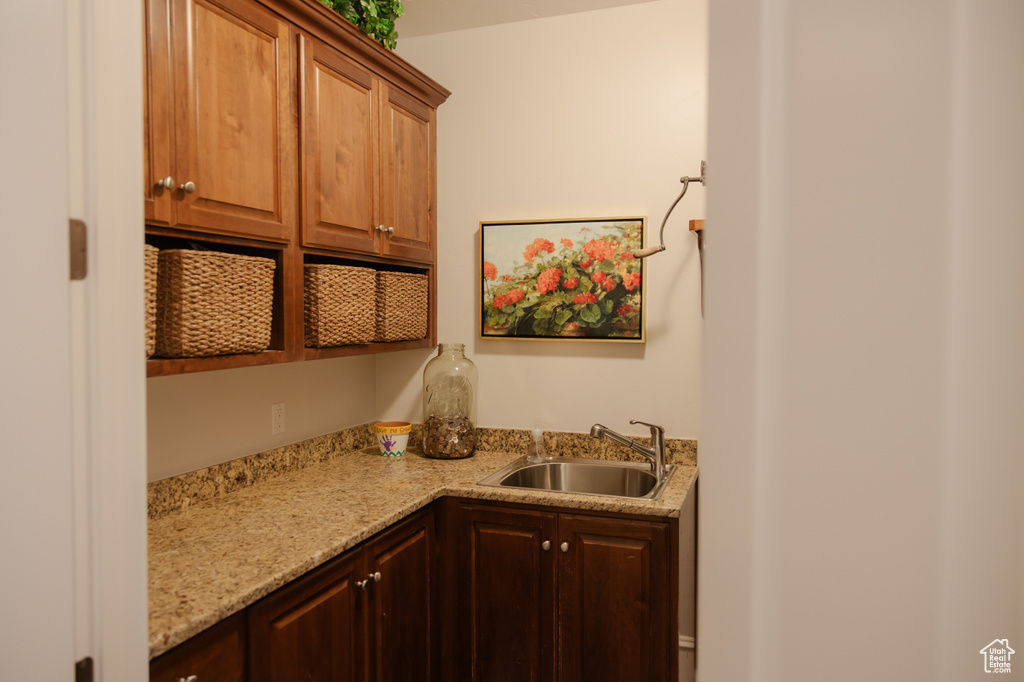 Kitchen with a sink and light stone counters