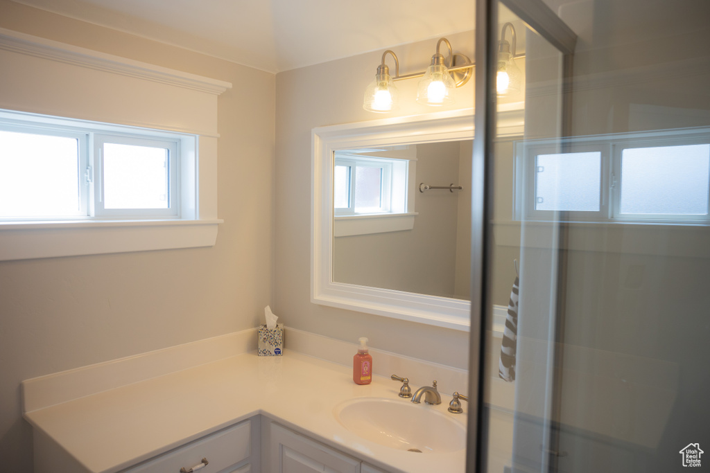 Full bathroom with vanity and a shower with door