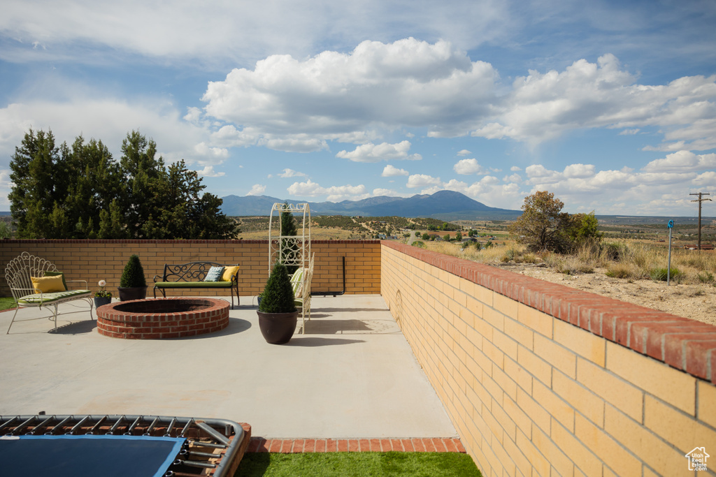 View of patio featuring an outdoor fire pit and a mountain view