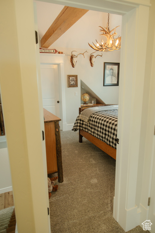 Bedroom with a chandelier, carpet, and beamed ceiling