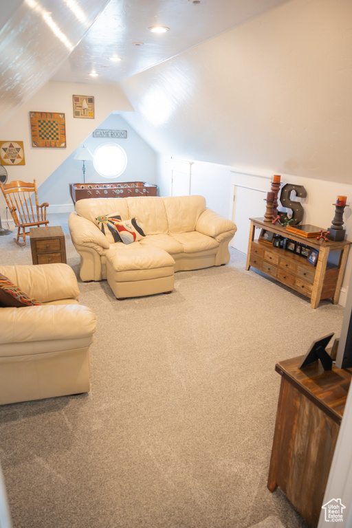 Carpeted living area featuring vaulted ceiling