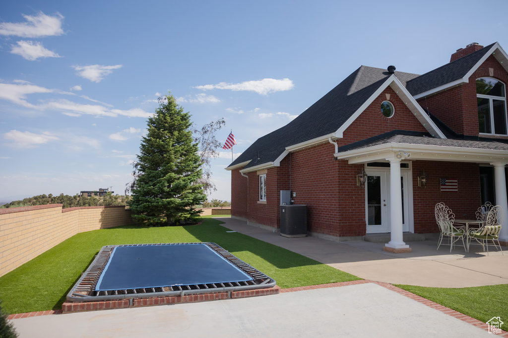 View of home\\\\\\\\\\\\\\\'s exterior with brick siding, a patio area, a shingled roof, and cooling unit