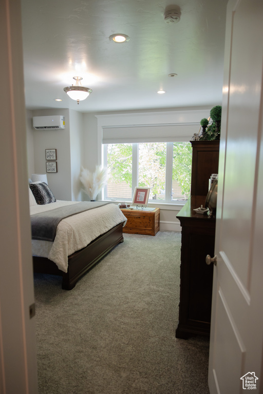 Bedroom with carpet, an AC wall unit, and recessed lighting