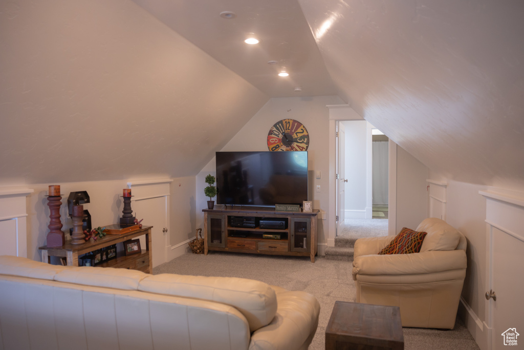 Living room featuring carpet flooring, lofted ceiling, and baseboards