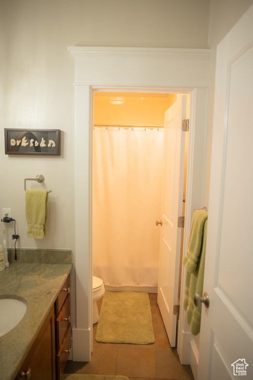 Bathroom with vanity, toilet, and curtained shower
