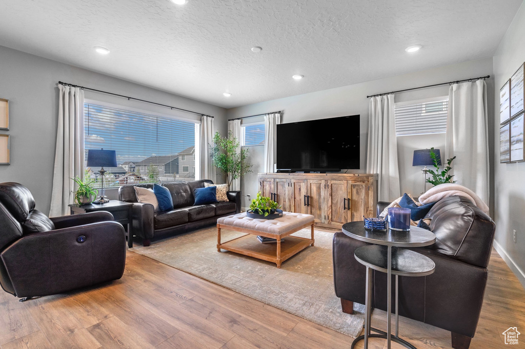Living area featuring wood finished floors, a textured ceiling, and recessed lighting