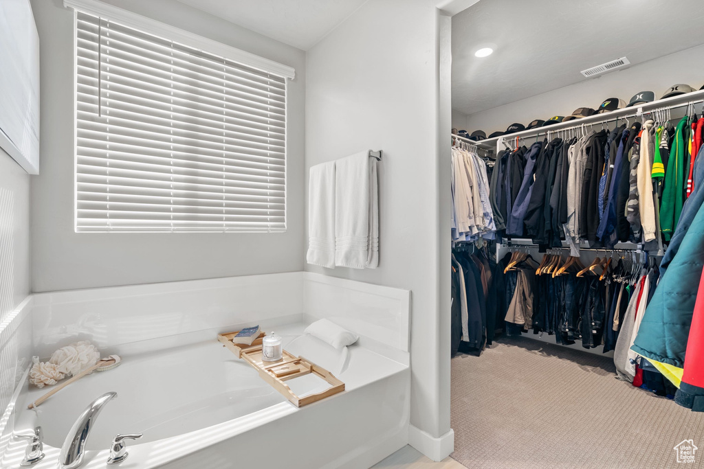 Bathroom featuring a bath and a spacious closet