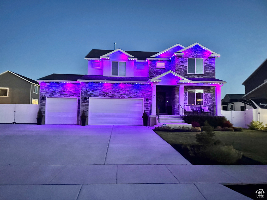 View of front facade with stone siding, a garage, and concrete driveway
