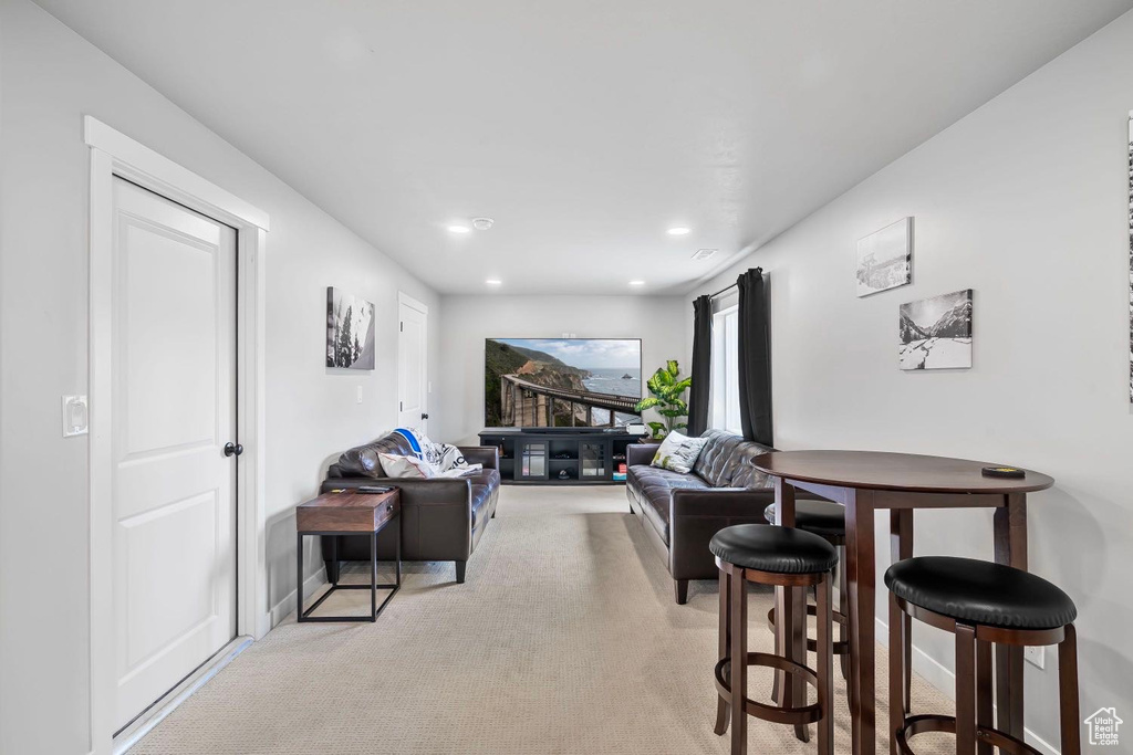 Living area featuring light carpet and recessed lighting