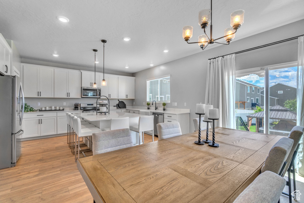 Dining area featuring a chandelier, light wood-type flooring, and recessed lighting