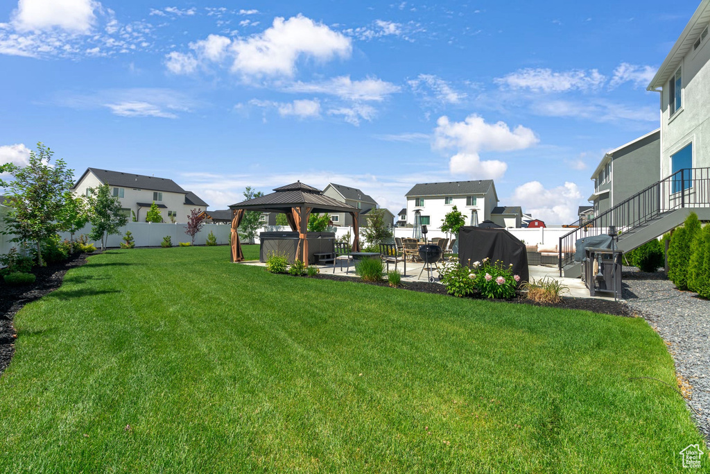 View of yard with a patio area, a gazebo, a residential view, a hot tub, and stairway