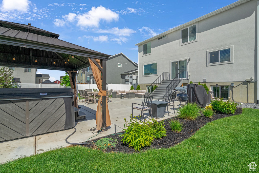 Back of house with an outdoor living space with a fire pit, a gazebo, stucco siding, and a patio