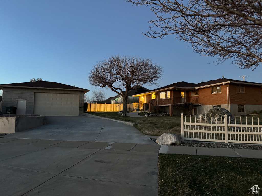 View of front facade featuring a garage, an outbuilding, a balcony, and concrete driveway
