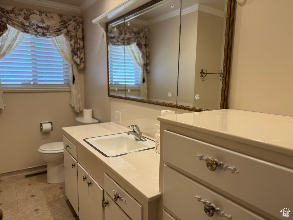 Bathroom featuring ornamental molding, vanity, toilet, and tile patterned flooring