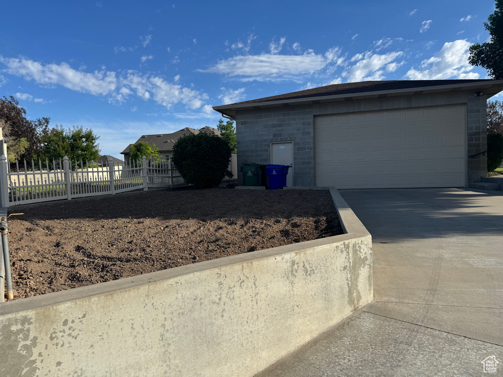 View of property exterior with a garage and driveway