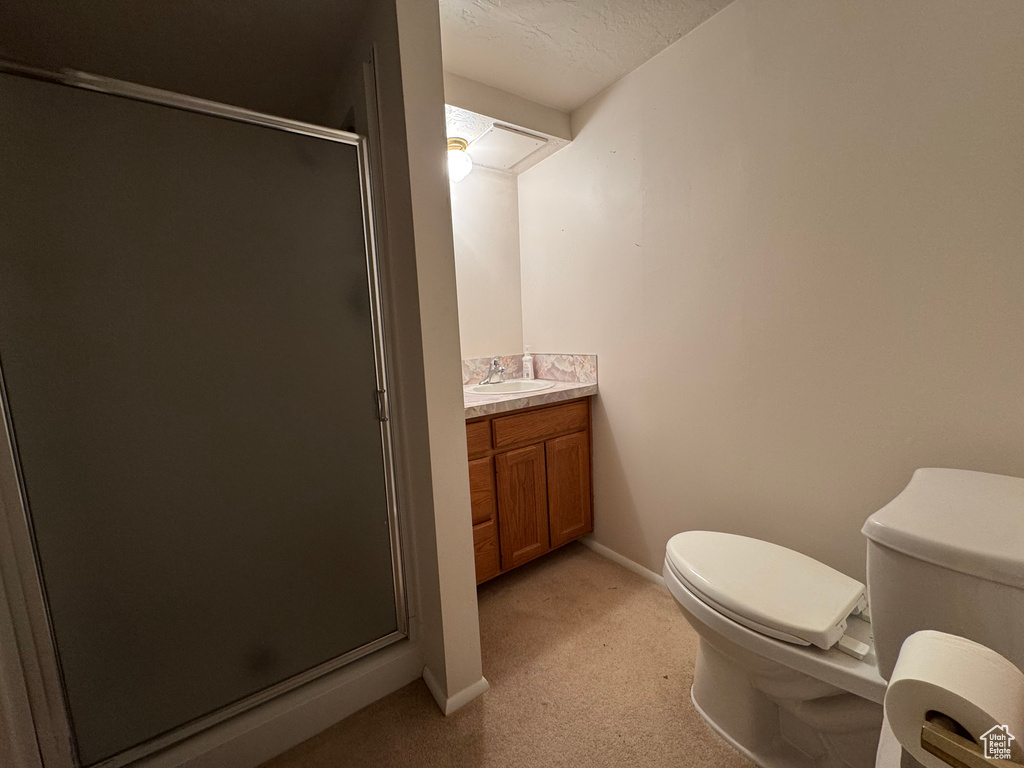 Bathroom with toilet, vanity, a shower stall, and baseboards