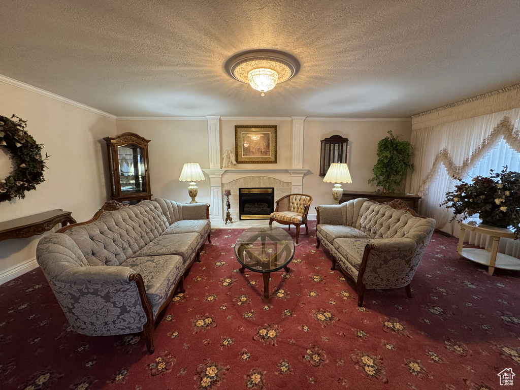 Living area with carpet flooring, a textured ceiling, a fireplace, and ornamental molding