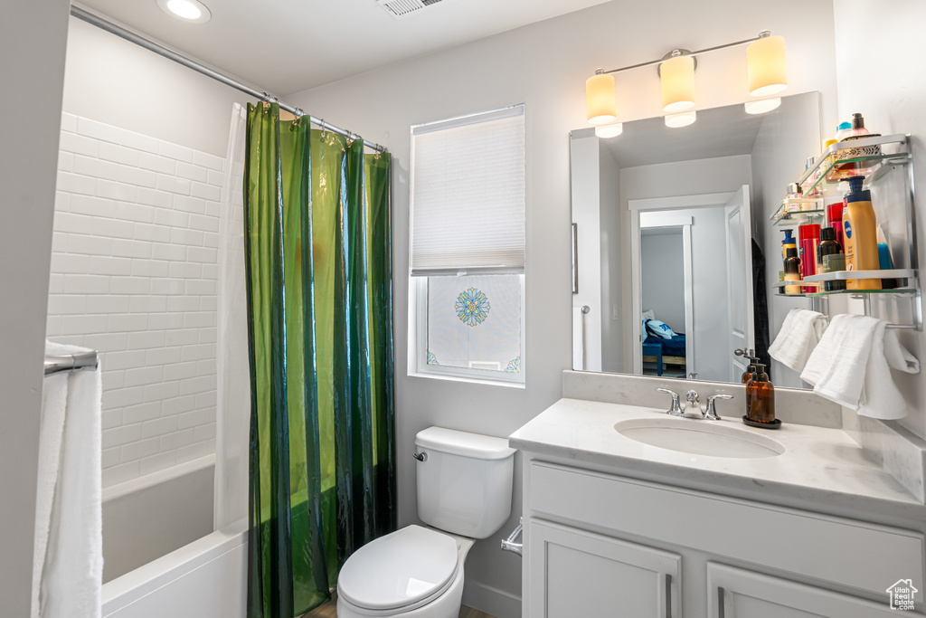 Full bath with vanity, shower / tub combo with curtain, and toilet