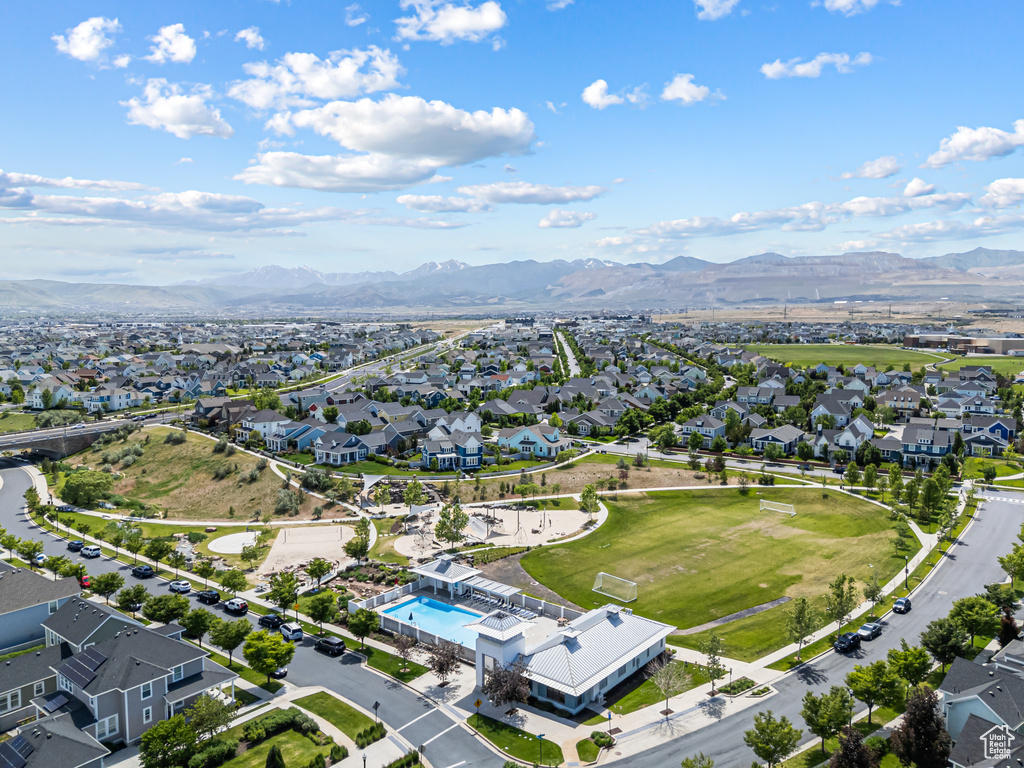 Aerial view of property's location with nearby suburban area, a mountain backdrop, and a pool