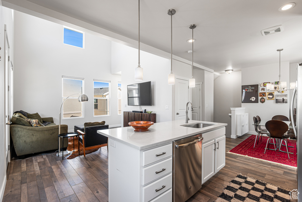 Kitchen with dishwasher, a sink, dark wood-style floors, open floor plan, and white cabinets