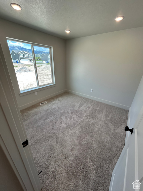 Carpeted empty room with baseboards, recessed lighting, and a textured ceiling