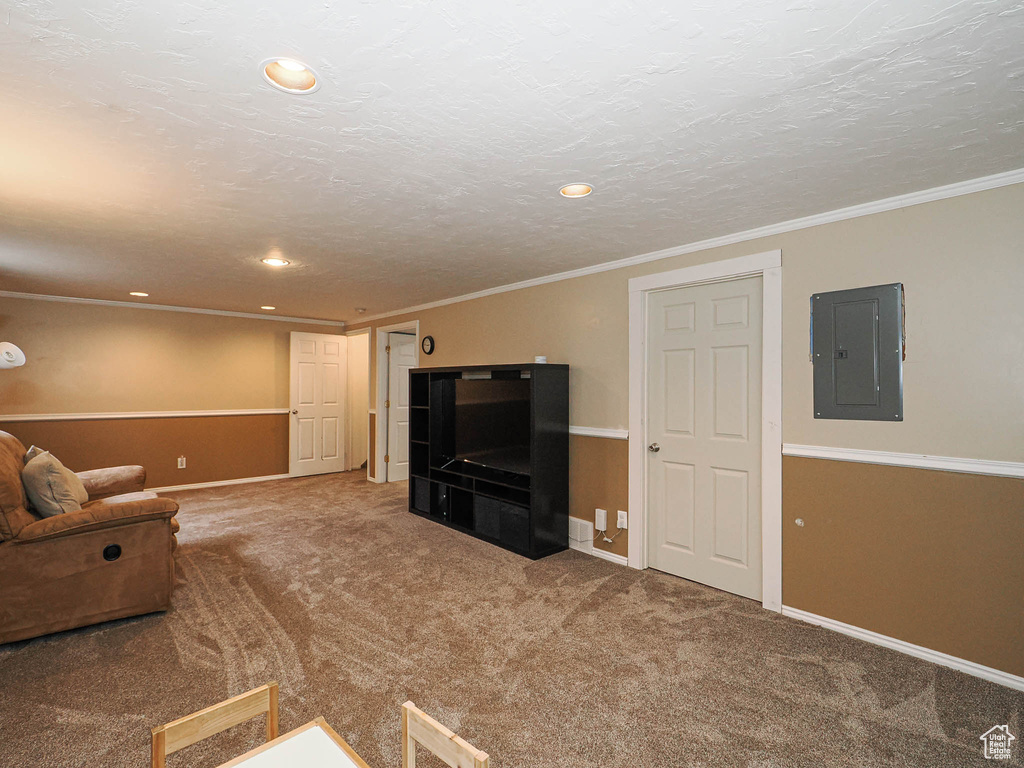 Unfurnished living room featuring electric panel, carpet flooring, baseboards, recessed lighting, and ornamental molding