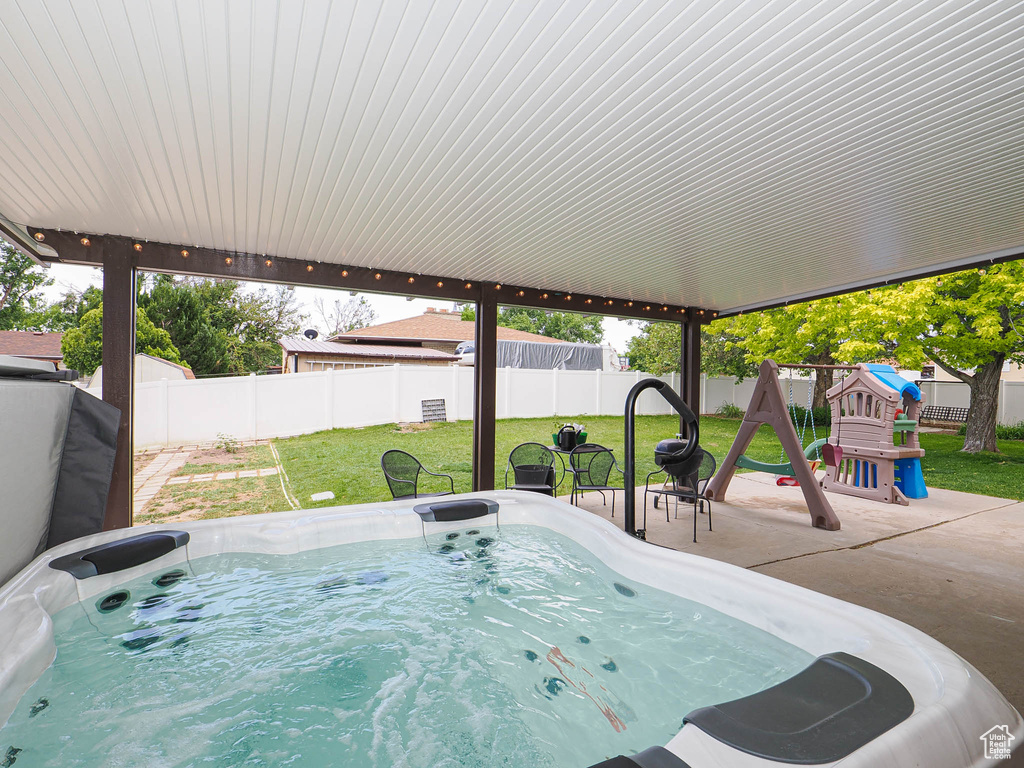 View of patio / terrace featuring a hot tub and a playground