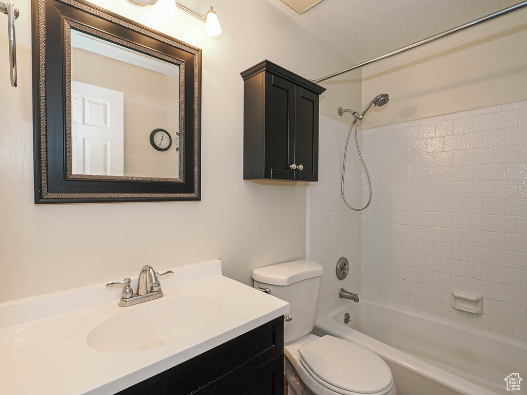 Bathroom featuring toilet, vanity, and shower / washtub combination