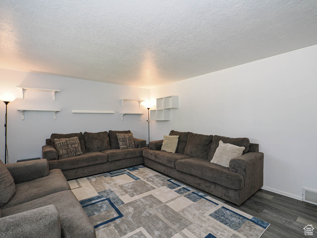 Living room with wood finished floors and a textured ceiling