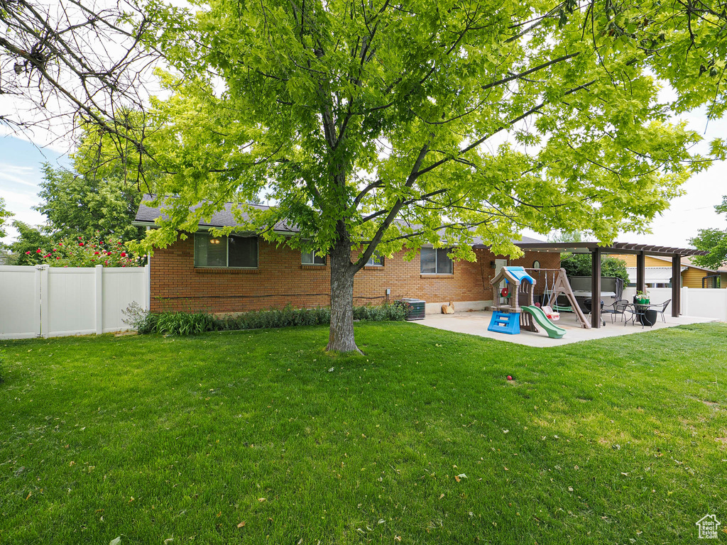 View of yard with a playground, a patio area, and central AC