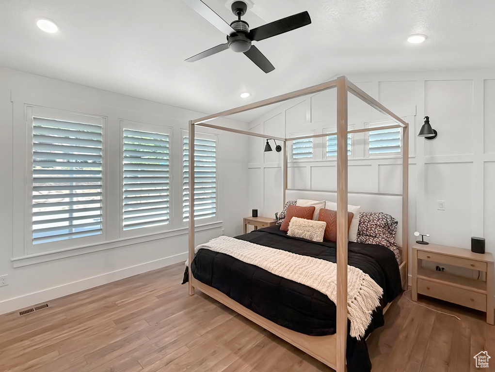 Bedroom featuring vaulted ceiling, light wood-type flooring, baseboards, multiple windows, and recessed lighting